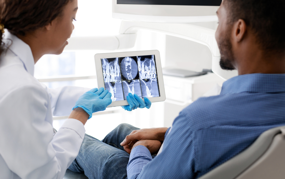dentist showing patient his digtal X-ray scans of smile